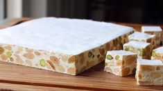 several pieces of cake sitting on top of a wooden table next to some white cubes