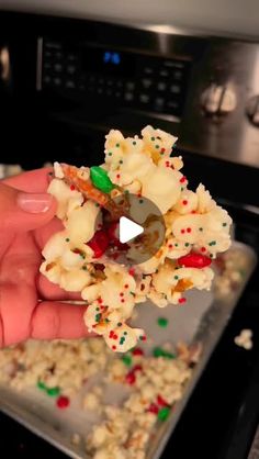 someone is holding some kind of food in front of an oven with sprinkles on it