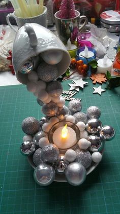 a candle that is sitting on top of a glass bowl filled with balls and ornaments