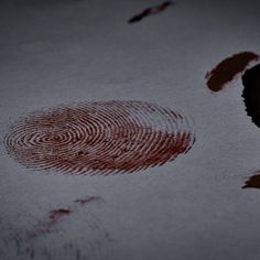 two finger prints are shown in the middle of a bed sheet that has red ink on it