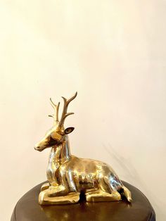 a golden deer statue sitting on top of a wooden table