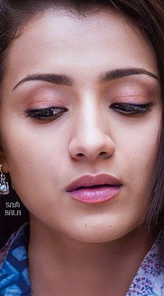 a close up of a person wearing earrings and looking at the camera with an intense look on her face