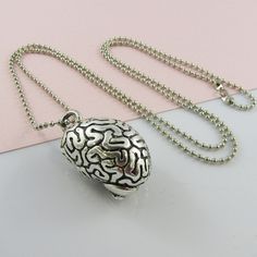 Quirky 3D Brain pendant on a long length sweater chain necklace.       Length of the necklace is approximately 68cm      Charm/Pendant Measurements  26mm x 23mm Silver Novelty Necklaces With Charms, Novelty Silver Necklaces With Charms, Metal Pendant Long Necklace As Gift, Metal Long Necklace With Round Pendant As Gift, Silver Necklaces With Charms, Brain Necklace, Zombie Brain, Silver Necklace Simple, Science Jewelry