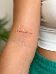 a woman's arm with a small tattoo that says sunshine on the inside of it