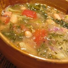 a wooden bowl filled with soup on top of a table