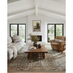 a living room with two couches and a coffee table in front of the fireplace