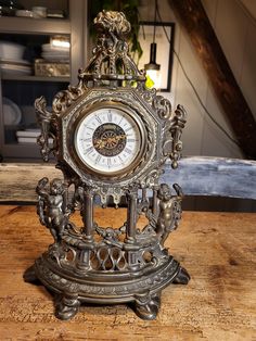 an ornate metal clock sitting on top of a wooden table next to a stair case