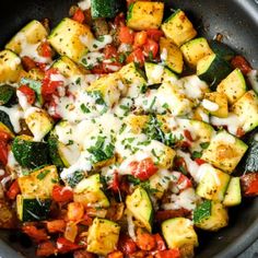 a pan filled with vegetables and cheese on top of a table