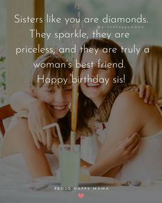 two women sitting next to each other in front of a cake with candles on it