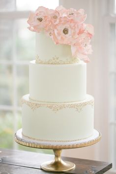 a white wedding cake with pink flowers on top