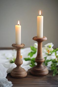 two candles sitting on top of a wooden table