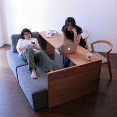 two people sitting on couches using laptops