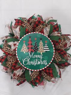 a merry christmas wreath with trees and leopard print on the front, sitting on a white background