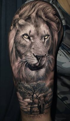 a man's arm with a lion and tree tattoo on the left side of his arm