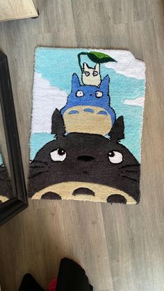 the rug has totoro on it and is next to a pair of shoes