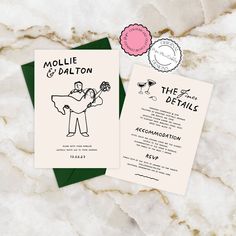 the wedding stationery is laid out on top of the marble slab, and features an illustration of a bride carrying her groom