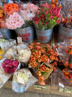 many different types of flowers on display in buckets