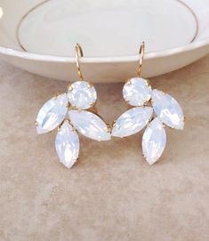 "Gorgeous pair of rhinestone leaf earrings featuring 6mm round and 10x5 marquise white opal Swarovski crystals.  Gold metal finish. Earring are 1\" long, 3/4\" wide." Leaf Earrings Gold, Gold Rhinestone Earrings, White Opal Earrings, Prom Earrings, Gold Leaf Earrings, Wedding White, Crystal White, Wedding Jewelry Earrings, Gold Rhinestone