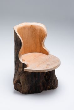 a wooden chair sitting on top of a piece of tree trunk in front of a white background