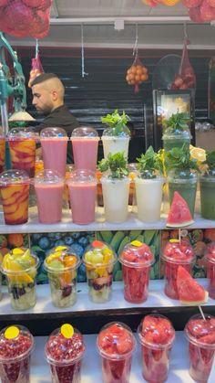 there are many drinks on the shelves in this store that is filled with different fruits and veggies