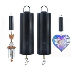 two black cylinder shaped wind chimes are next to each other and one has a heart on it