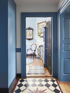 a hallway with blue walls and checkered rug