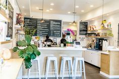 the inside of a coffee shop with white stools