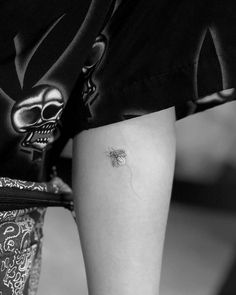 a person with a tattoo on their leg wearing shorts and holding a purse in her hand