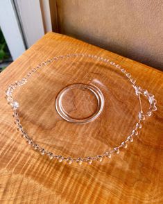 a wooden table topped with a clear glass bowl on top of it's side