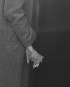 two people are holding hands in black and white