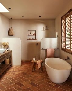 a bathroom with brick flooring and large bathtub next to a sink in the corner