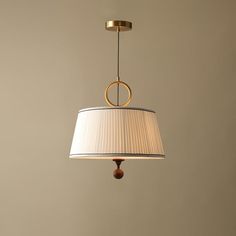 a light hanging from a ceiling with a white lamp shade on it's side