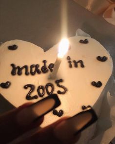 a heart shaped cake with the words made in 2009 written on it and a lit candle