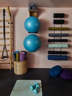 there is a yoga mat and exercise balls in the room with other equipment on the wall