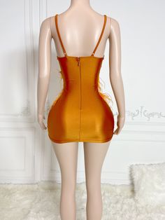 a mannequin wearing an orange mini dress