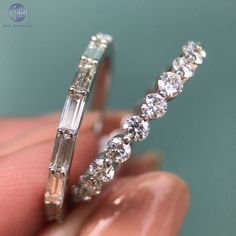 a close up of a person holding a ring in their hand with diamonds on it