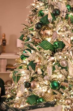 a white christmas tree with green and gold ornaments