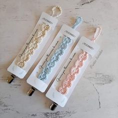 three crocheted hair clips in pastel blue, light pink and white colors