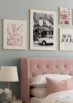 a bed with pink headboard and pillows in front of pictures on the wall above it