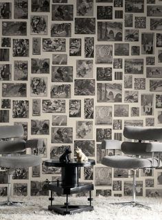 a chair and table in front of a wall with pictures on it