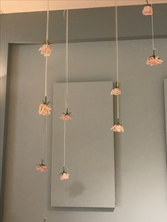 pink flowers are hanging from the ceiling in a room with gray walls and white trim