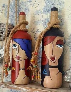 two wooden bottles with faces painted on them sitting on a shelf next to a wall