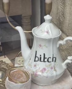 a white tea pot sitting on top of a table