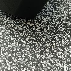 the floor is covered in black and white speckles, with small dots on it