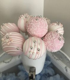 some pink and white decorated chocolates in a vase