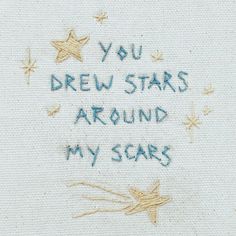 the embroidered message is written in blue ink on a white piece of cloth with gold stars