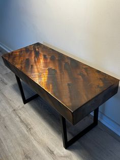 a wooden table sitting on top of a hard wood floor next to a white wall