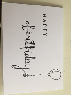 a handwritten happy birthday card on a white paper with black writing and a balloon