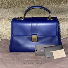 Beautiful Blue “Atlantic” Color Bottega Venetta Piazza Bag. New With Tags. Has One Small Spot On Front Can’t Even Notice It! Comes With Dustbag, Care Card, Price Tag, And Extra Strap. Poshmark Will Authenticate. Top Handle And Shoulder Strap. The Blue Crossover Flap Pull Down With Interior Zipper And Patch Pocket. Great For Day Time Or Evening!! A Classic!! The Stock Photo And Photos I’ve Taken Are The Same Color. The Color Is A Deep Blue. High-end Blue Box Bag With Detachable Handle, High-end Blue Tote Bag, High-end Blue Tote Box Bag, High-end Blue Top Handle Box Bag, High-end Blue Box Bag For Shopping, Luxury Square Flap Bag With Top Carry Handle, High-end Blue Box Bag For Everyday Use, High-end Blue Box Bag For Formal Occasions, High-end Blue Bag With Double Handle