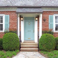 a blue door is in front of a brick house